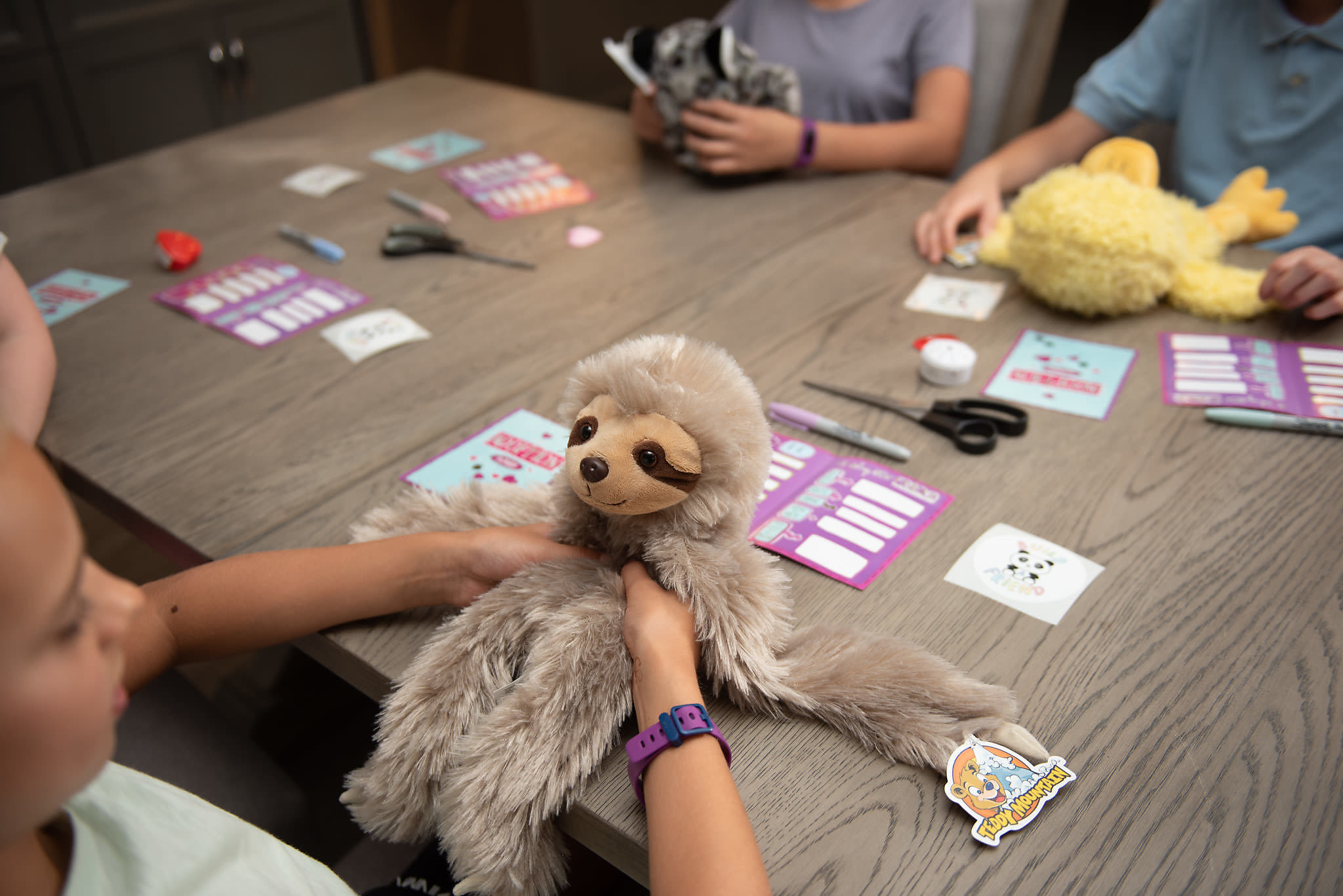 Kids stuffing Build A Friend animals at the table