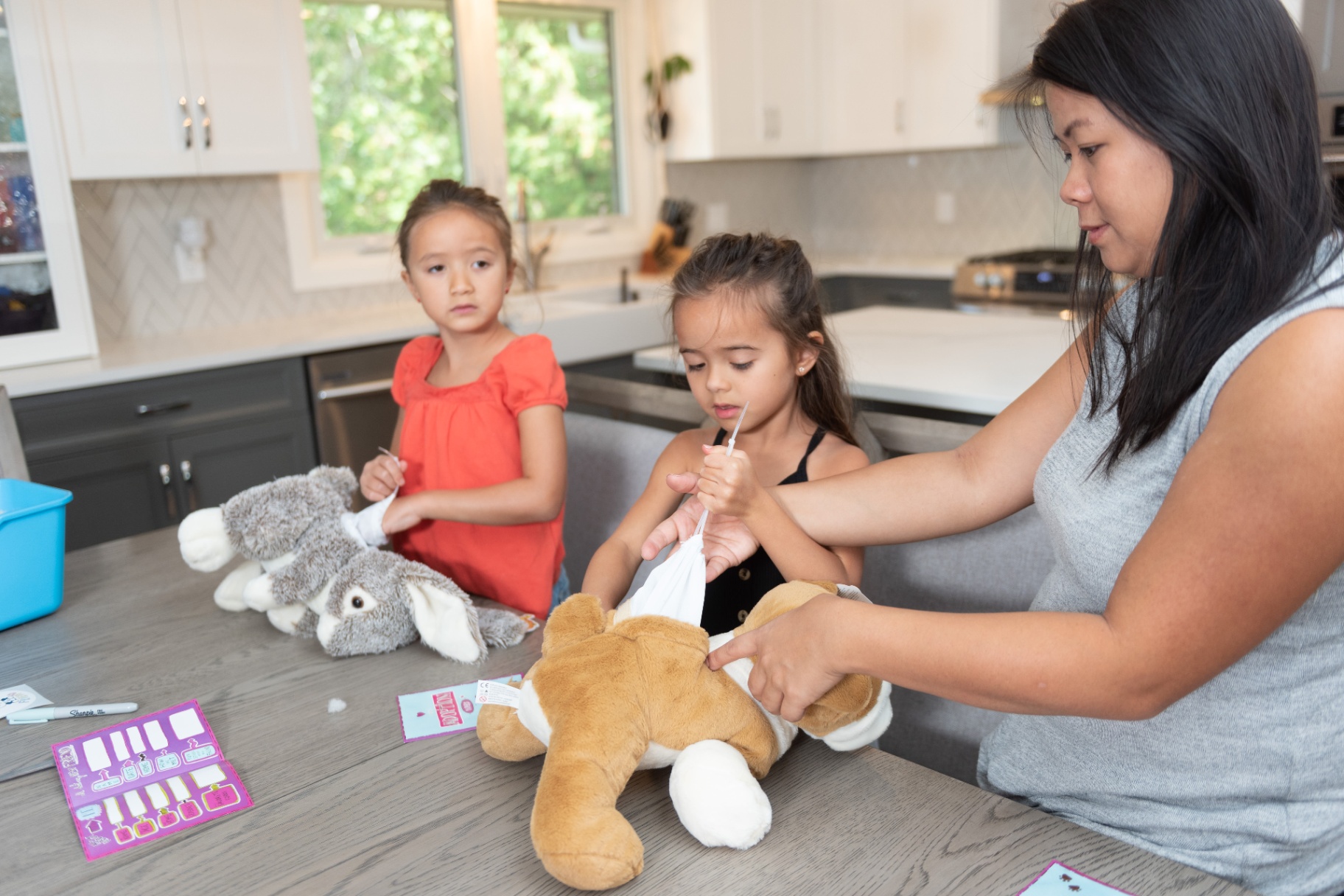 Kids filling out adoption certificates during a Build A Friend kit activity